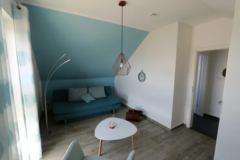 Wohnzimmer im Obergeschoss mit türkiser Wand