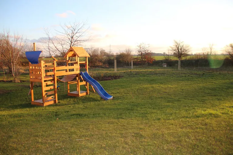Spielplatz im Abendlicht mit weiter Wiese